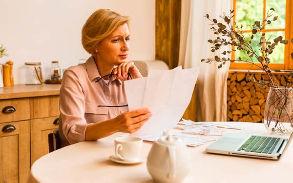 Žena čte doručené dokumenty k nařízené dražbě nemovitosti